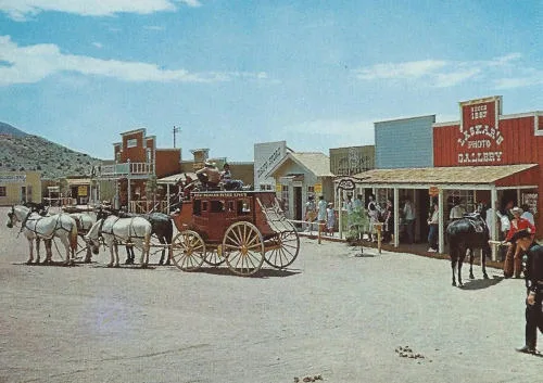 A photograph an old west style line of building fronts with stage coach in foreground.