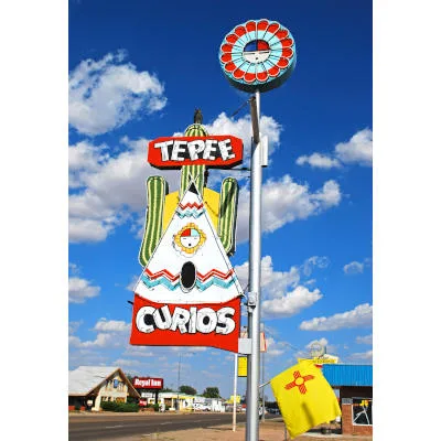 Saturated colors photograph of a sign pole against blue sky with clouds. 